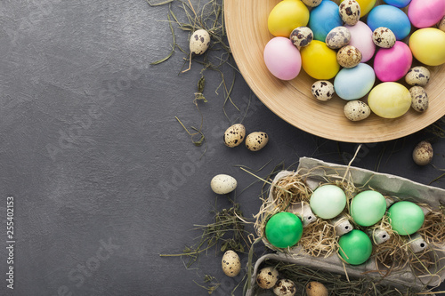 Colored Easter and quail eggs set on black table