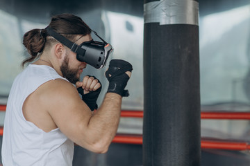 Muscular boxer man with vr glasses fighting in simulated virtual reality