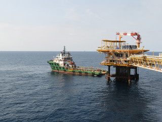 Supply boat support oil and gas industry. Supply boat transfer cargo to oil and gas industry and moving cargo from the boat to the platform. Boat is waiting transfer cargo and crews to platform. 