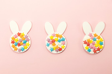 Three paper Easter bunny on a pink background. Easter background and greeting card. 