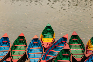 Traditional colored wooden rowing boats in Pokhara, Nepal an early morning before they go out onto the lake. Classic view in Pokhara. 