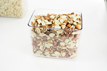 Nut mix in glass jars, hazelnuts, almonds, cashew on white background. Selective focus, copy space.