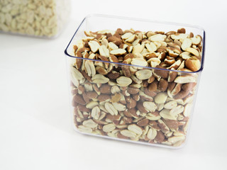 Nut mix in glass jars, hazelnuts, almonds, cashew on white background. Selective focus, copy space.