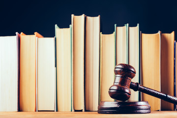 Court hammer and books on black background.
