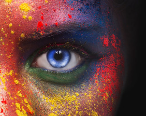 Blue eye of woman looking at camera on black