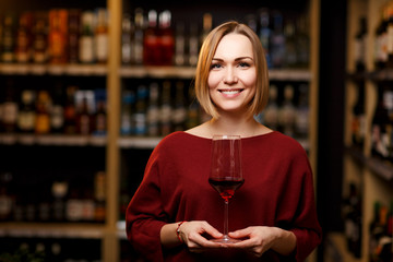 Photo of girl with glass in hands at store with wine