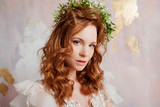 Portrait of a young beautiful woman in wedding dress with wreath of fresh flowers.