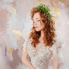 Portrait of a young beautiful woman in wedding dress with wreath of fresh flowers.