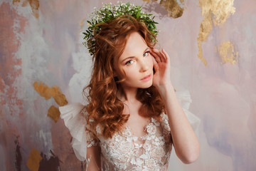 Portrait of a young beautiful woman in wedding dress with wreath of fresh flowers.