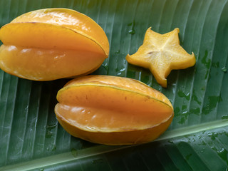 Carambola fruit on the background of green banana leaves © Siriporn