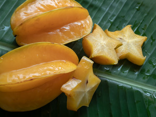 Carambola fruit on the background of green banana leaves © Siriporn