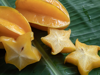 Carambola fruit on the background of green banana leaves © Siriporn