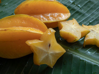 Carambola fruit on the background of green banana leaves © Siriporn