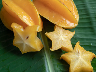 Carambola fruit on the background of green banana leaves © Siriporn