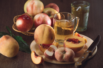 Still life of peaches and juice on a dark background