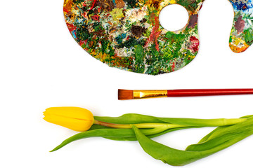 Palette with colorful paints. Colorful oil painting palette with a brush reaching in. Paint brushes and paints for drawing. tulip on a white background
