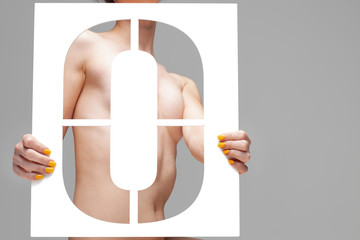 nude girl holding stencil letter o