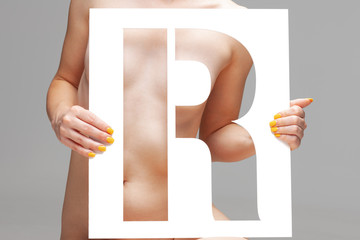 nude girl holding stencil letter r