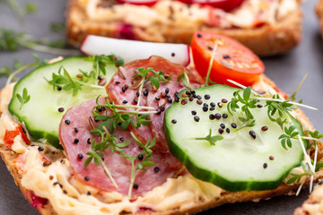 Sandwiches with cream cheese, vegetables and salami.