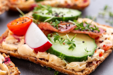 Sandwiches with cream cheese, vegetables and salami.