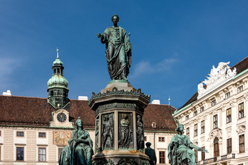 Fototapeta premium Austria, Vienna, Hofburg Palace, In der Burg: Famous emperor Francis statue and Austrian National Library facade at Josefsplatz in the city center of the capital with blue sky - concept Habsburg