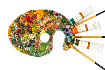 Fototapeta premium Palette with colorful paints. Colorful oil painting palette with a brush reaching in. Paint brushes and paints for drawing. tulip on a white background