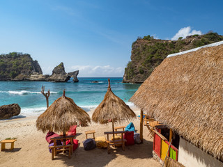 Sea coast view with little houses standing on the beach near by sea. Atuh beach, Nusa Penida island. Popular travel destination on Bali holidays. Indonesian background. October, 2018
