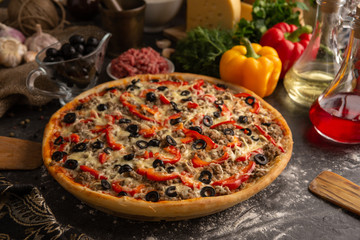 Pizza with minced meat, paprika and olives for the restaurant menu.