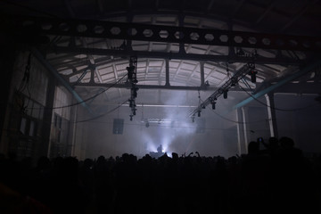 DJ playing in front of a big crowd in hangar