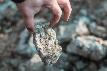 Male hand holding a stone.