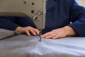 Obraz premium Closeup of an older woman in a furniture factory who is sewing the material for the sofa