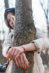 Fototapeta premium Restraint of women concept. A woman with her hands tied to a tree.
