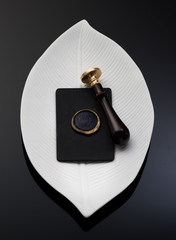 Wax stamp on an elegant business card and a wax seal on a tray, top view