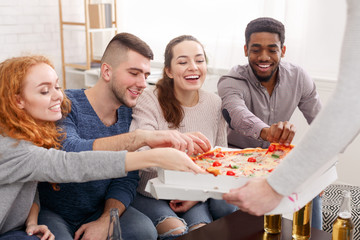 Friends taking slices of hot pizza from cardboard box