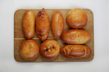 Traditional pies on a wooden board. Top view on a white background.