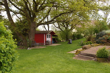 Fototapeta na wymiar Gartenhütte unter einem alten Baum