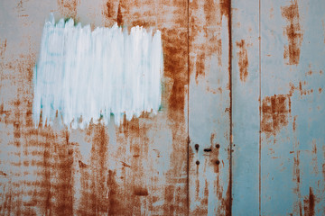Rust metal surface. Partly rusty background. Rough oxide plate close-up. White painted spot. Copy space, mock up. Hard decay texture. Oxidation of steel. Partially rusted metal panel. Peeling paint.