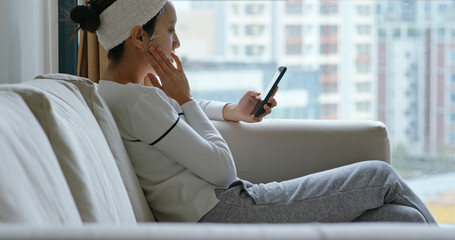 Woman apply the paper mask and use of mobile phone