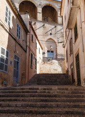 empty narrow dark street in an ancient, historic city; buildings and street in brown tones