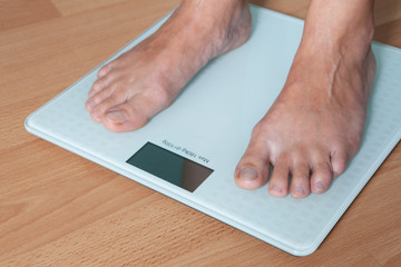 The legs of a young woman on the scales. Weight check. The concept of losing weight.