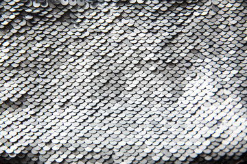 Silver blinking sequins. Shiny sparkling texture. Glow. Abstract