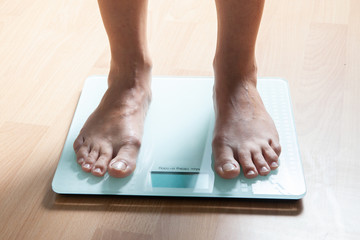 The legs of a young woman on the scales. Weight check. The concept of losing weight.