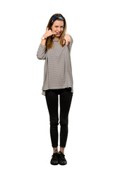 A full-length shot of a Young woman with headscarf making phone gesture and pointing front over isolated white background