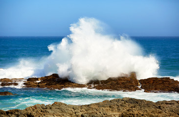 Huge wave breaks on rocky coast