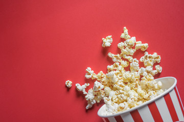 Spilled popcorn on a red background, cinema, movies and entertainment concept
