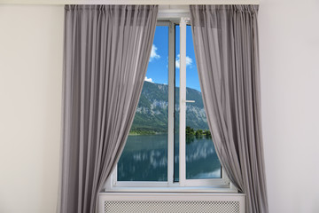 Beautiful view from new modern window with curtain in room