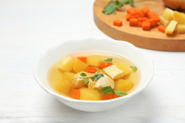 Dish with fresh homemade chicken soup on wooden table