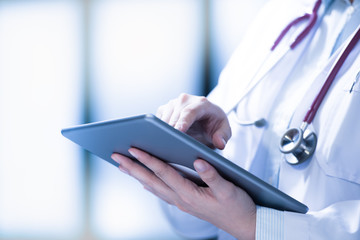 Medical doctor using smart tablet for work in hospital