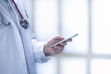 Medical doctor using smart phone for work in hospital