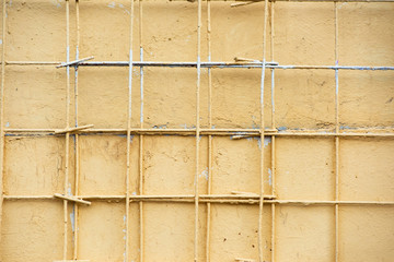 Texture of a yellow wall with a metal grill